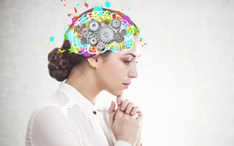A woman in profile with a colourful illustrated brain and gears drawn over her head.