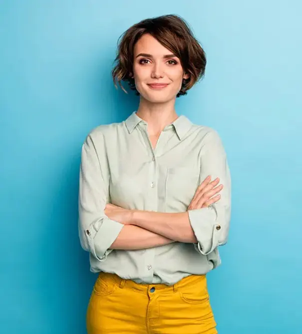 A woman in a mint shirt stands with her arms crossed against a bright teal background.